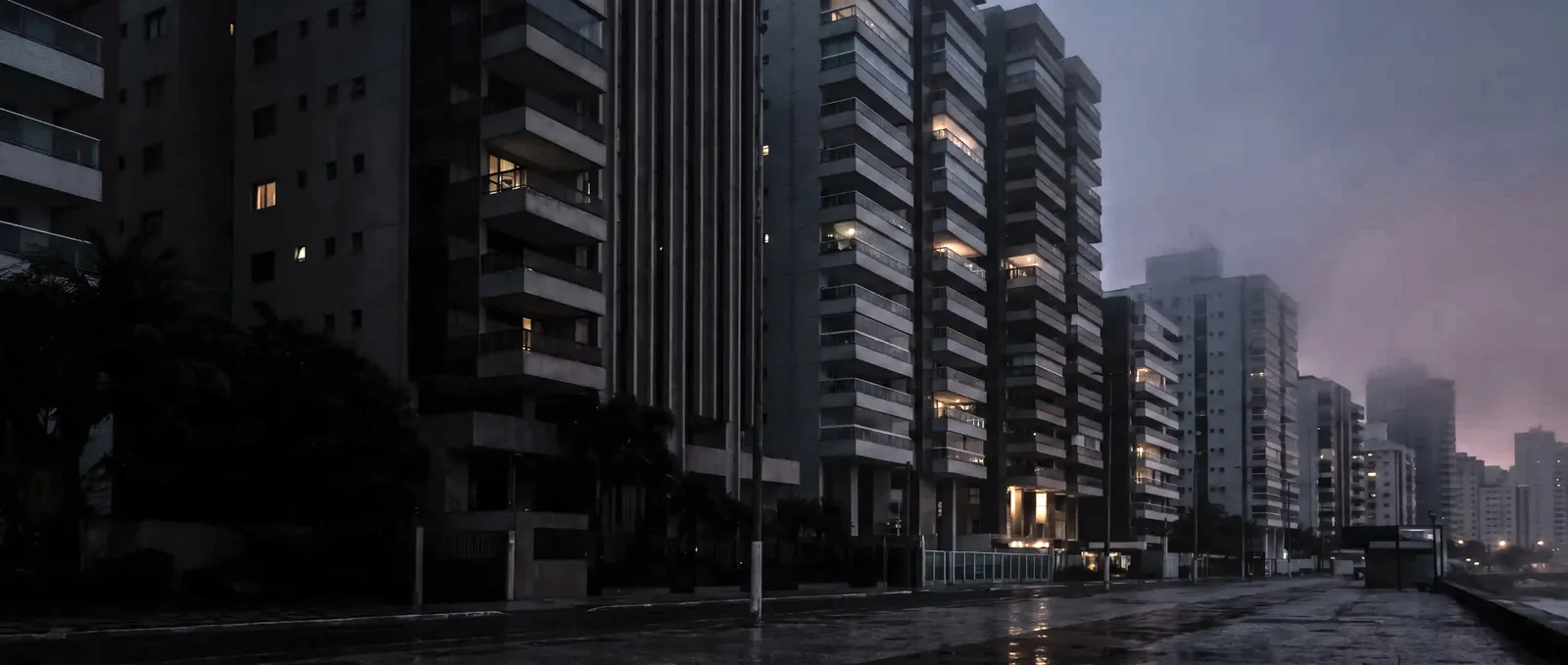 Edifícios ao anoitecer, com as janelas começando a acender