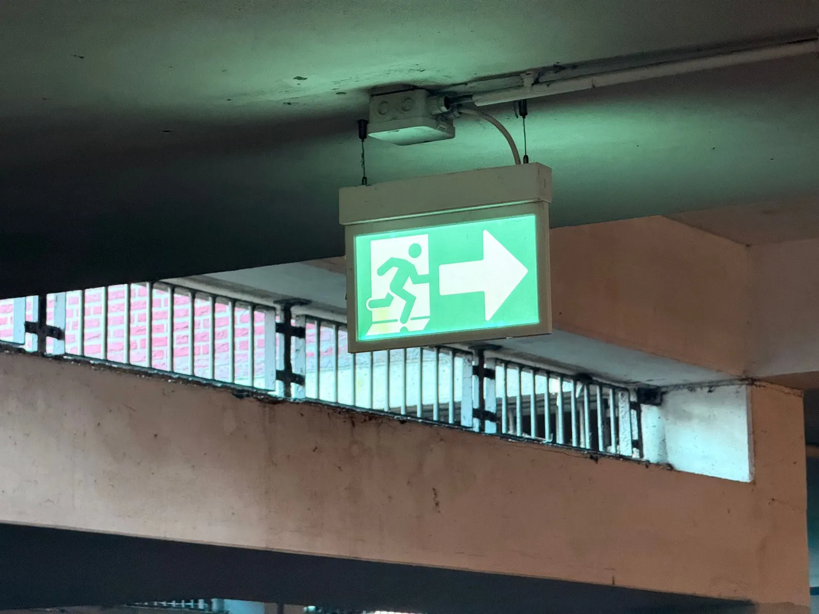 Placa iluminada de saída de emergência sob a laje de uma garagem